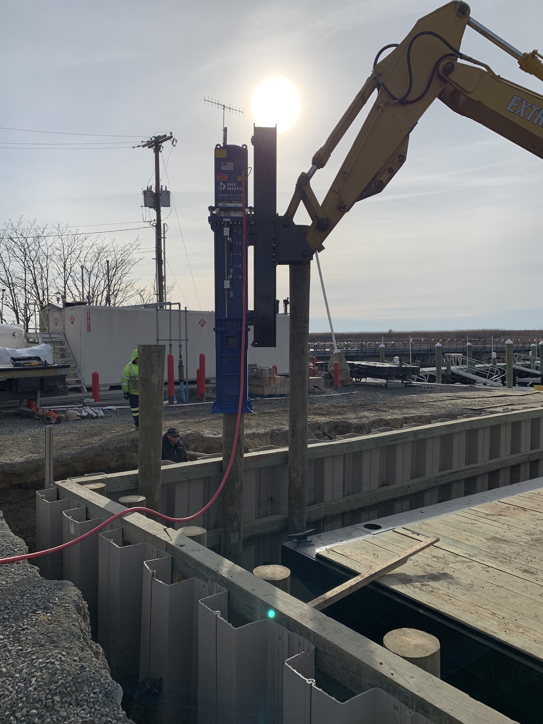 Model 24-2500 attached to excavator arm driving foundation beams