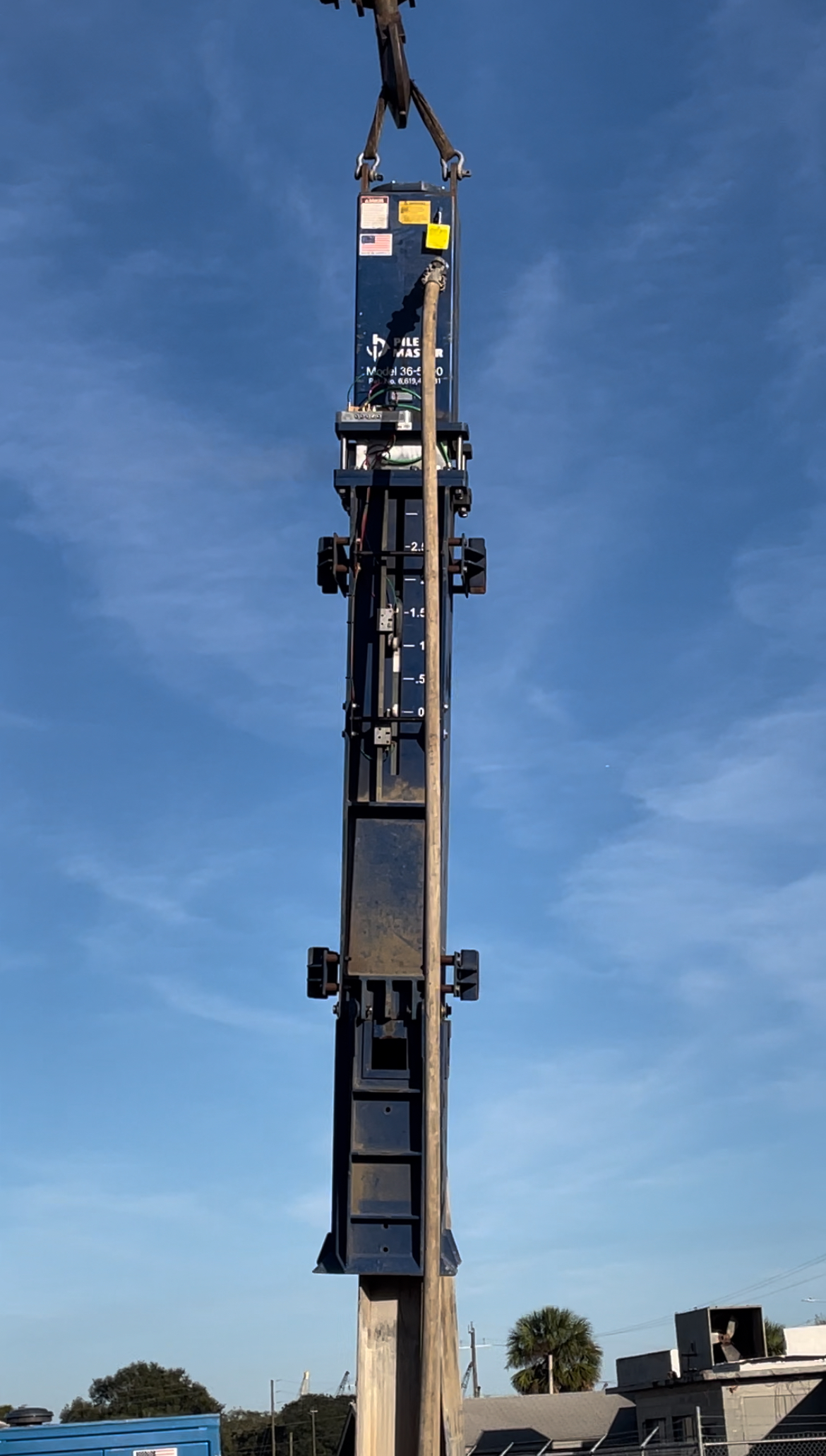 Aerial shot of Model 36-500 hanging from crane assembly against a blue sky.